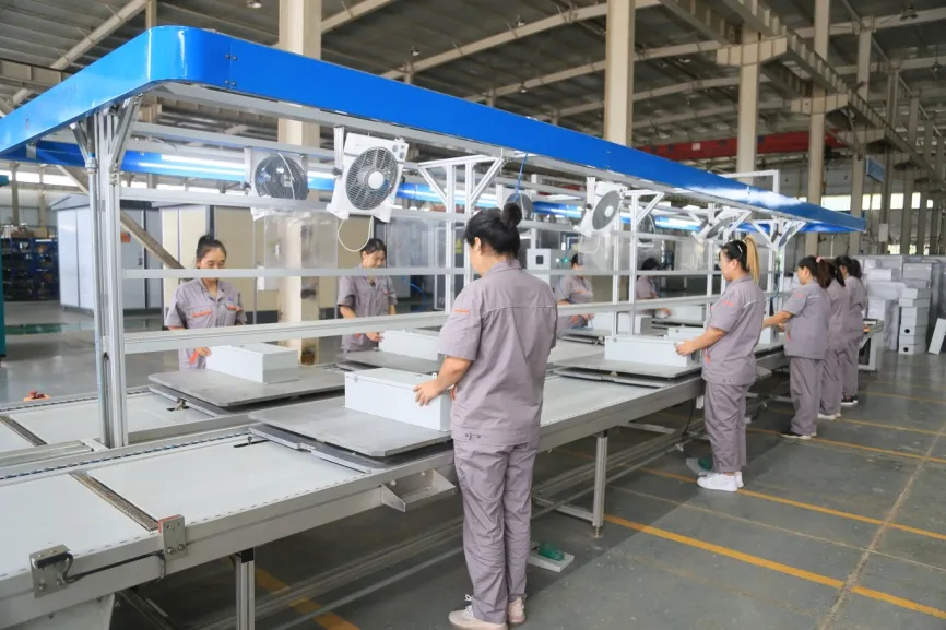 Electrical equipment production scene with workshop personnel, assembly benches and components